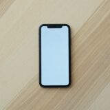 テーブルの上に置かれたスマートフォン。紛失・盗難時の位置確認と回線停止のイメージ