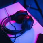 ヘッドセットをつけてオンラインで話しながらゲームをする人（ゲームチャットのイメージ）
