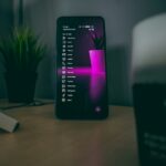 机の上のスマートフォン。SMS認証コードの受信状況を確認する記事のイメージ写真