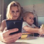 子どもと一緒にスマートフォンを確認する家族