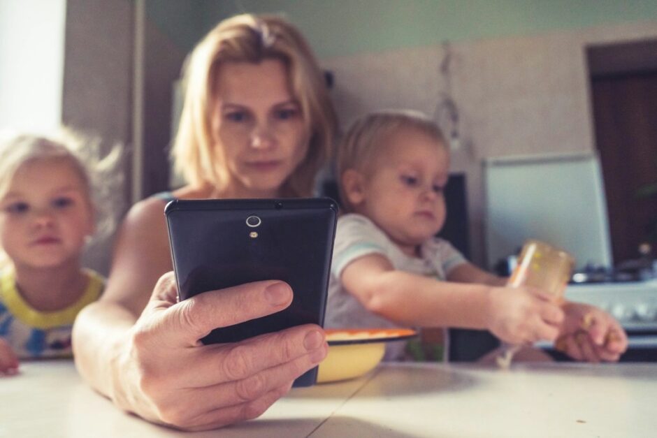子どもと一緒にスマートフォンを確認する家族