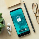 スマートフォンを手にフィッシングSMSや偽メールを確認するイメージ