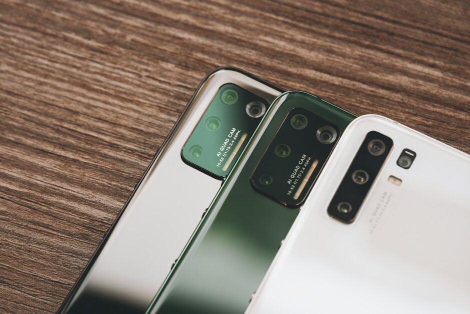 木のテーブルに並んだ2台のスマートフォン。古いスマホから新しいスマホへのデータ移行のイメージ